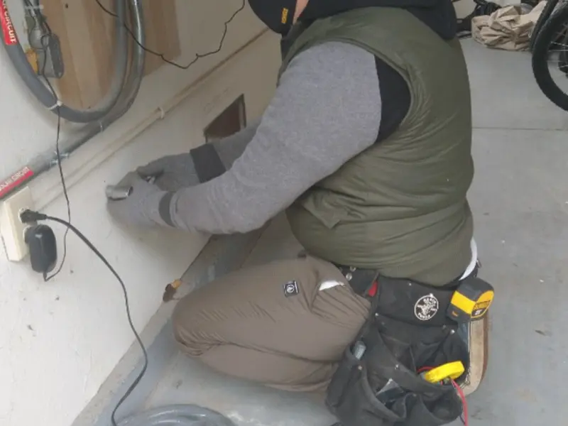 Electrician performing outlet wiring in a Clinton garage